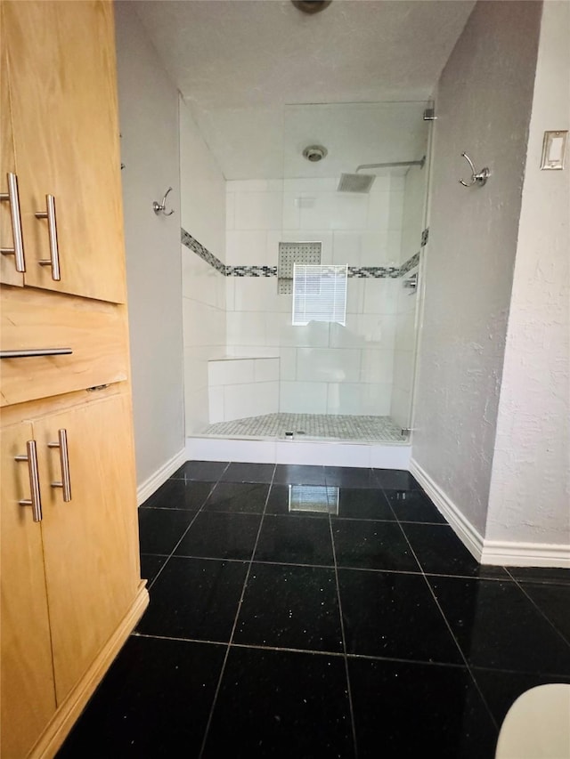 bathroom featuring tile patterned floors and a tile shower