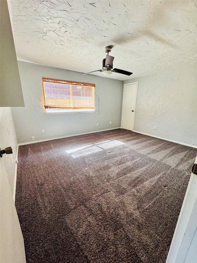 carpeted empty room with ceiling fan and a textured ceiling