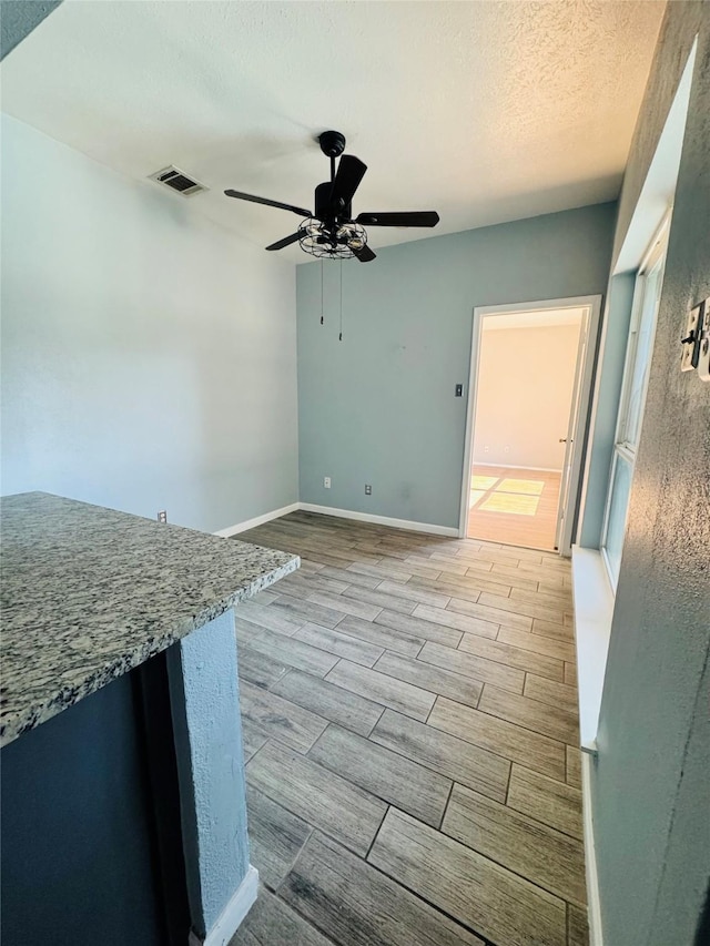 interior space featuring ceiling fan and a textured ceiling