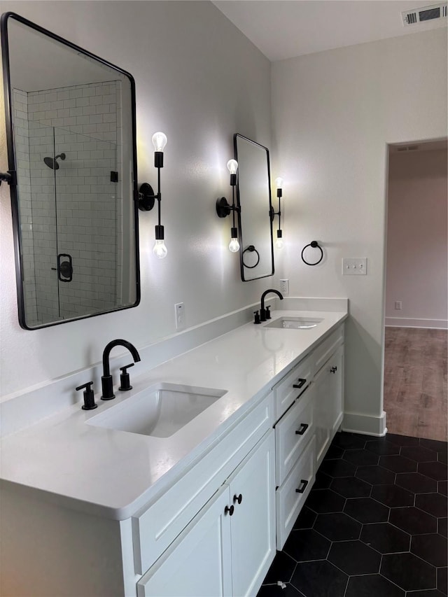 bathroom featuring vanity, a tile shower, and tile patterned floors