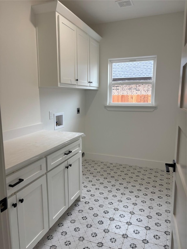 washroom featuring electric dryer hookup, washer hookup, and cabinets