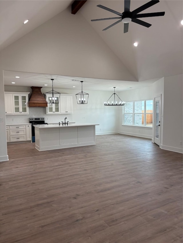 unfurnished living room featuring beamed ceiling, high vaulted ceiling, wood-type flooring, and ceiling fan with notable chandelier