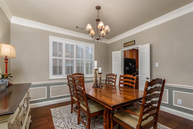 dining area with dark hardwood / wood-style flooring, a notable chandelier, and crown molding