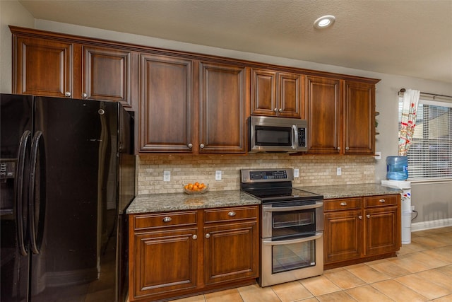 kitchen featuring appliances with stainless steel finishes, light stone counters, and backsplash