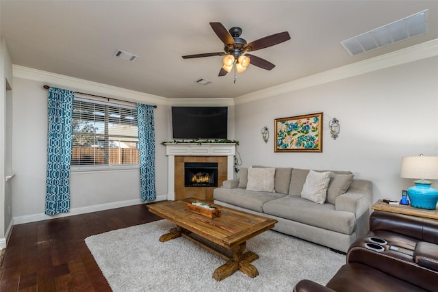 living room featuring ceiling fan, a fireplace, ornamental molding, and dark hardwood / wood-style flooring