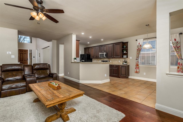 living area featuring light wood-style flooring, baseboards, ceiling fan, and recessed lighting