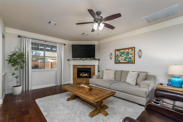 living area with a fireplace, visible vents, wood finished floors, and ornamental molding