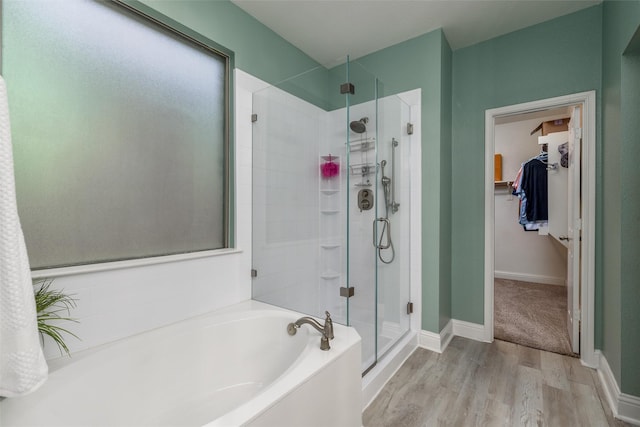 bathroom with plus walk in shower and hardwood / wood-style floors