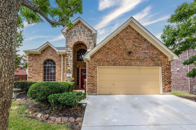 traditional-style home featuring a garage, stone siding, concrete driveway, and brick siding