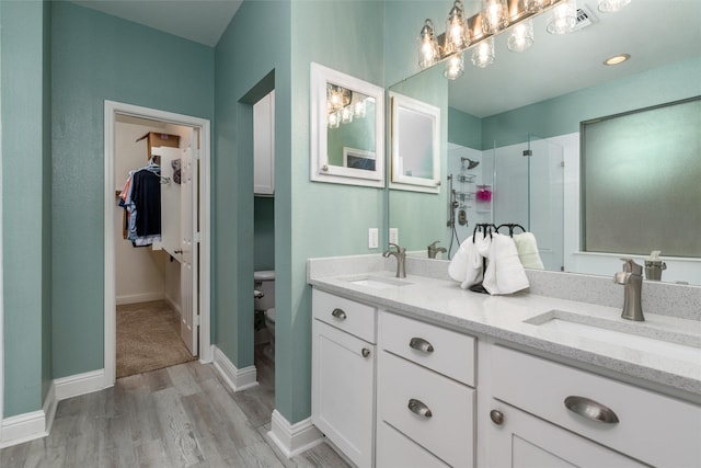 full bath with a stall shower, a sink, toilet, and wood finished floors