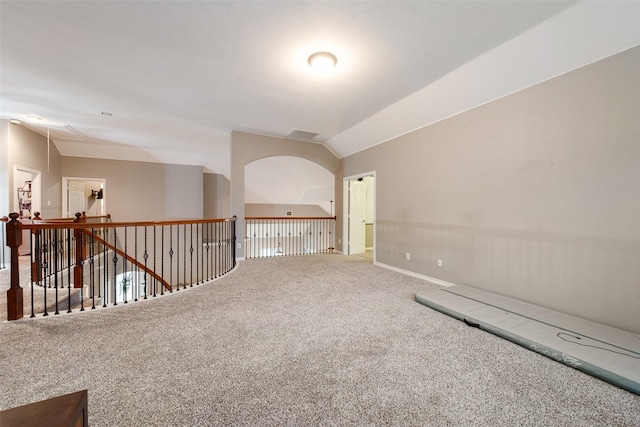 carpeted empty room featuring vaulted ceiling