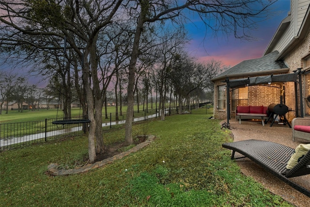 yard at dusk featuring outdoor lounge area