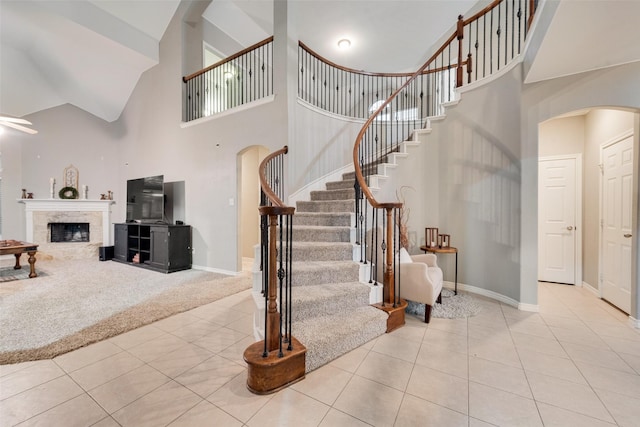 stairway featuring a healthy amount of sunlight, tile patterned floors, and a towering ceiling