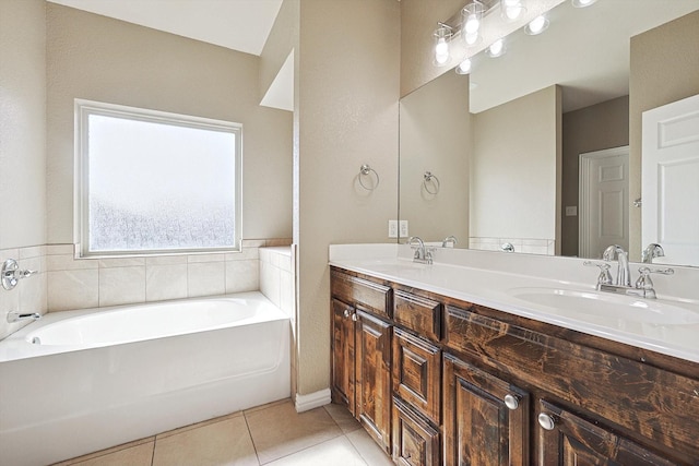 bathroom with double vanity, a garden tub, a sink, and tile patterned floors