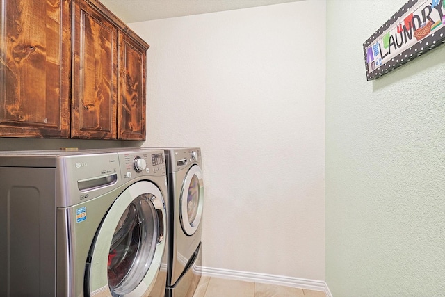 laundry room with light tile patterned flooring, independent washer and dryer, cabinet space, and baseboards