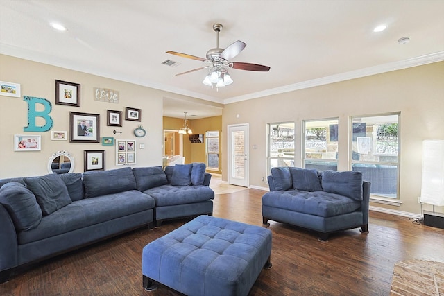 living room featuring dark wood-type flooring, visible vents, ornamental molding, and baseboards