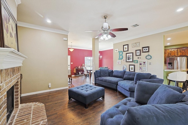 living room with visible vents, baseboards, dark wood-style flooring, crown molding, and a brick fireplace