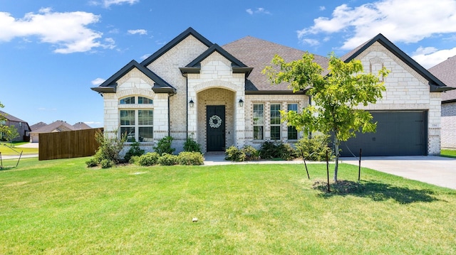 french country home with a garage and a front lawn