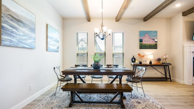 dining area with beam ceiling, an inviting chandelier, and light hardwood / wood-style floors