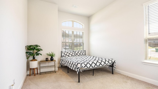 carpeted bedroom featuring multiple windows