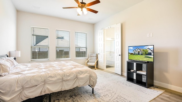 bedroom with ceiling fan, connected bathroom, and light hardwood / wood-style floors