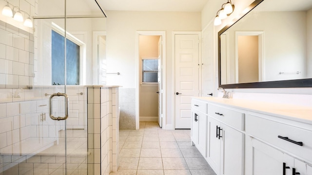 bathroom with vanity, tile patterned floors, tile walls, and walk in shower