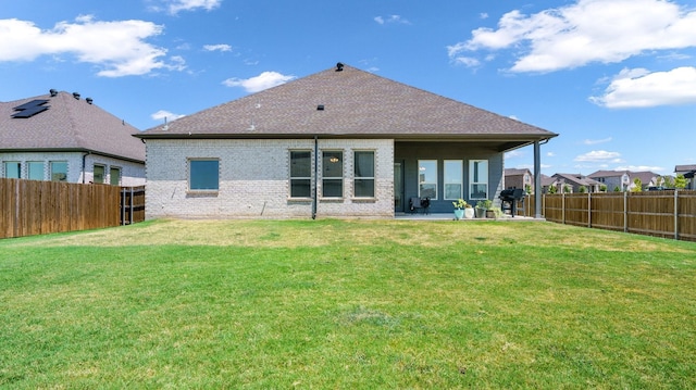 rear view of property with a yard and a patio area