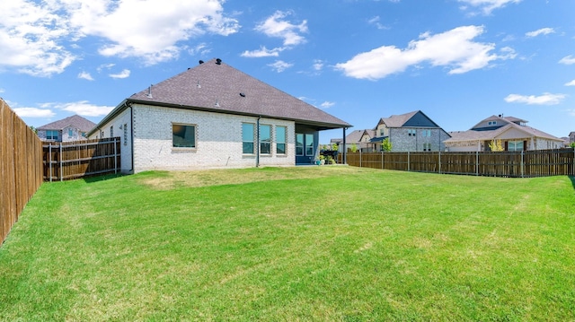 rear view of property featuring a lawn