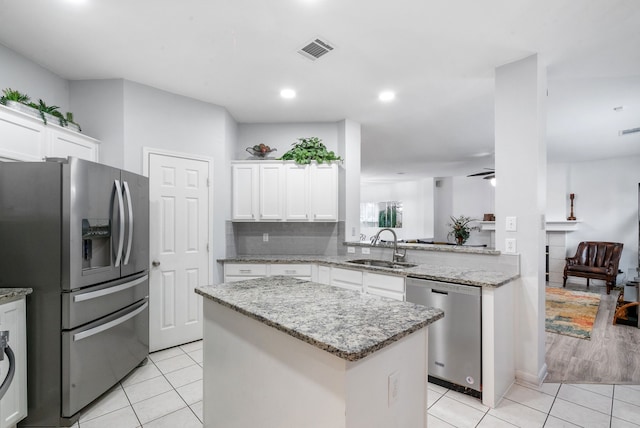 kitchen featuring white cabinetry, appliances with stainless steel finishes, sink, and kitchen peninsula