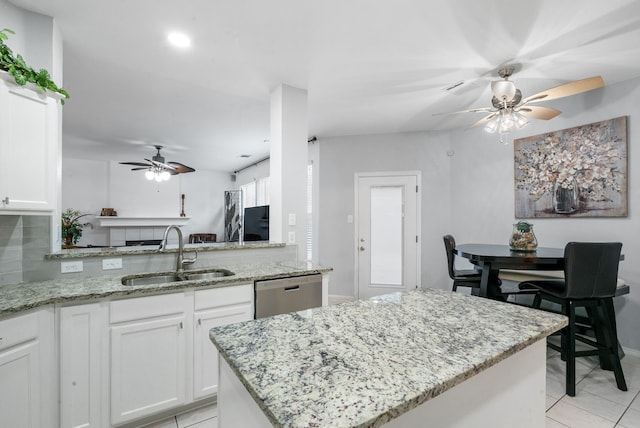 kitchen featuring sink, stainless steel dishwasher, white cabinets, and a kitchen island