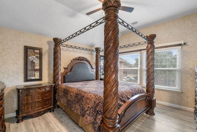 bedroom with ceiling fan, hardwood / wood-style floors, and a textured ceiling