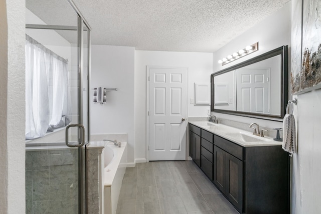 bathroom featuring vanity, separate shower and tub, and a textured ceiling