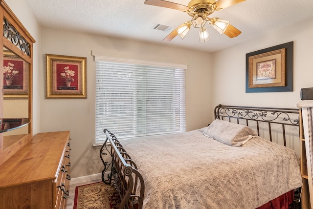 bedroom featuring ceiling fan and a textured ceiling