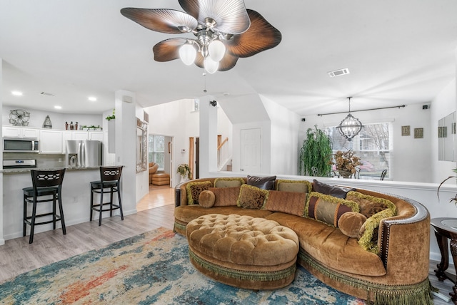 living room with an inviting chandelier and light hardwood / wood-style flooring