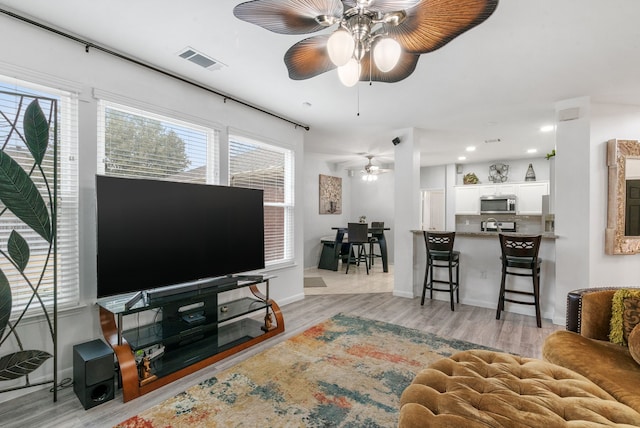 living room featuring ceiling fan, a healthy amount of sunlight, and light hardwood / wood-style floors