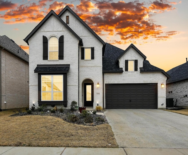 french country home featuring a garage and central AC unit