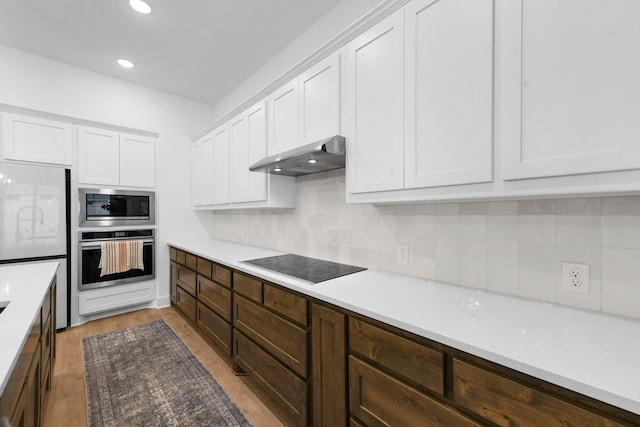 kitchen featuring white cabinetry, appliances with stainless steel finishes, dark brown cabinets, and backsplash