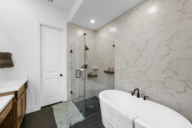 bathroom with vanity, tile patterned flooring, tile walls, and separate shower and tub