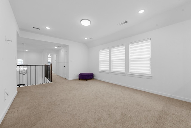 spare room with vaulted ceiling and light colored carpet