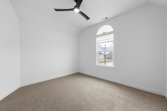 spare room with vaulted ceiling, carpet floors, and ceiling fan