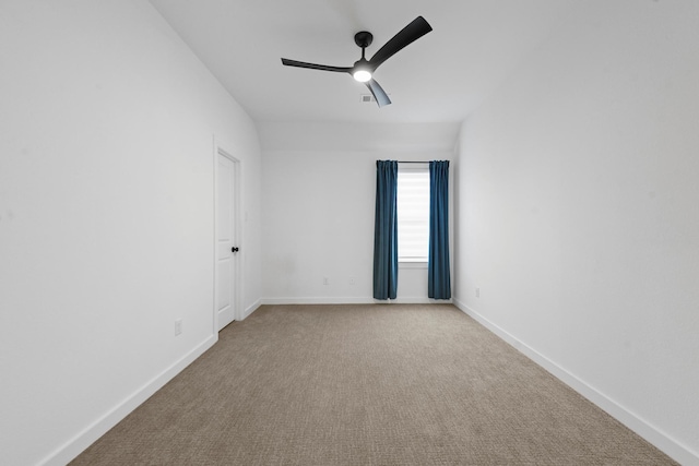 empty room featuring ceiling fan and light carpet