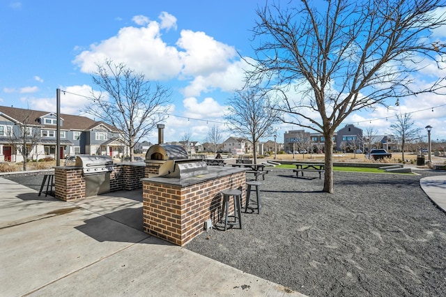 view of patio / terrace with exterior kitchen, a grill, and a bar