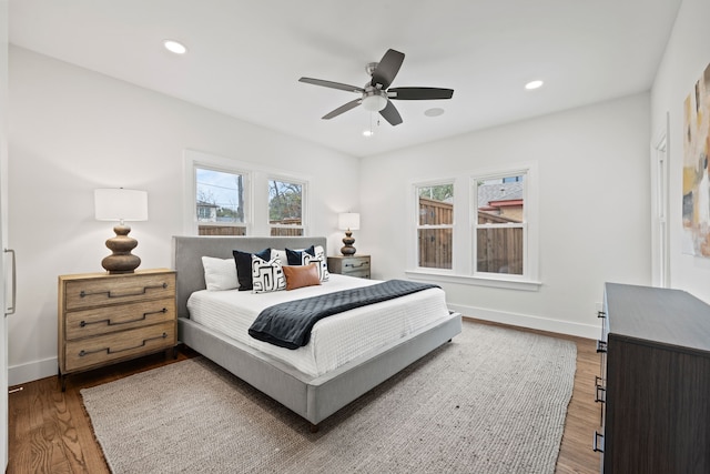 bedroom with wood finished floors, baseboards, and recessed lighting