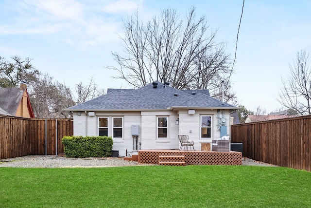 rear view of house featuring a fenced backyard, brick siding, a yard, and a deck