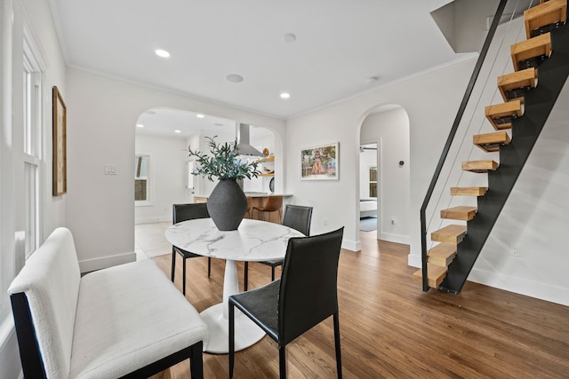 dining area with stairway, arched walkways, ornamental molding, and baseboards
