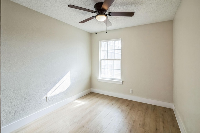 unfurnished room with ceiling fan, a textured ceiling, and light wood-type flooring