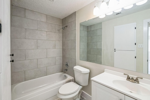 full bathroom with tiled shower / bath combo, vanity, a textured ceiling, and toilet