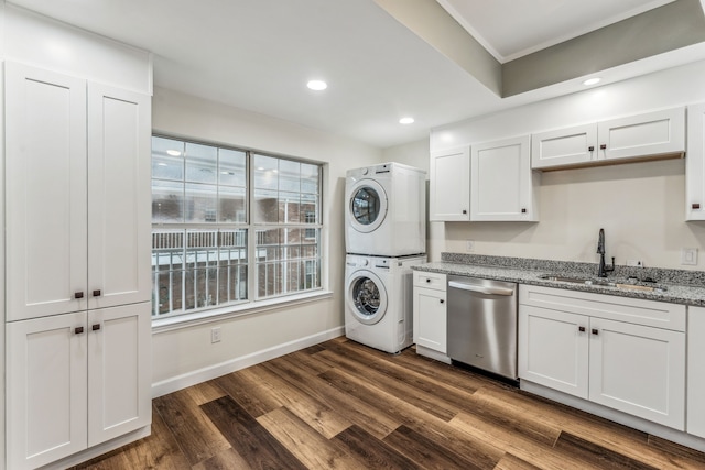 laundry area featuring sink, stacked washer / drying machine, and dark hardwood / wood-style floors