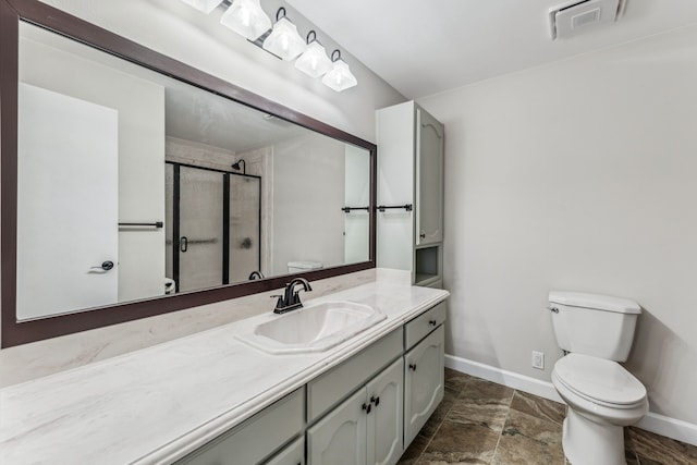 bathroom featuring a shower with door, vanity, and toilet