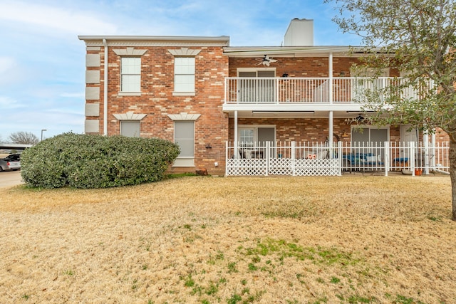 view of front of property with ceiling fan, a front yard, and a balcony